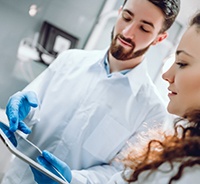 Dentist and patient discussing details of dental implant treatment