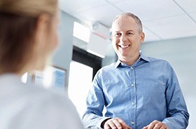 Man checking in at dental office reception desk