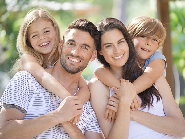 Family of four smiling outdoors