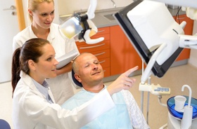 Dentist and patient discussing All-on-4 dental implant treatment