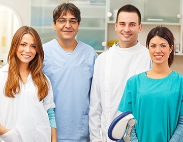 Four smiling dental team members