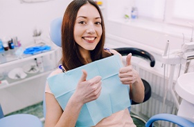 Patient in dental chair giving thumbs up