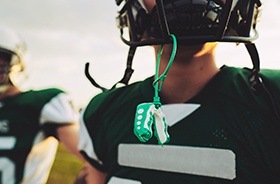 Green mouthguard hanging from football helmet