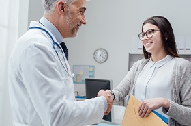 Patient shaking hands with dentist