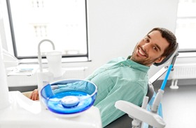 Smiling, relaxed male dental patient reclining in chair