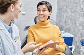 Happy dental patient talking with dentist