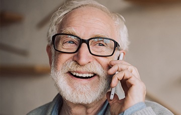 Older man smiling while talking on phone
