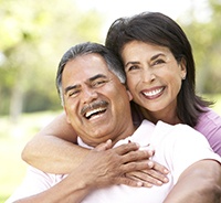 Older couple enjoying the money-saving benefits of dental implants