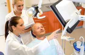 Patient and dental team discussing candidacy for implant dentures