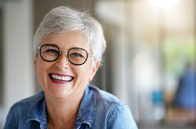 Confident senior woman enjoying benefits of implant dentures