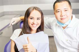 Patient giving thumbs up for dental implant salvage treatment