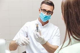 Plymouth implant dentist explaining dental implants to patient via model