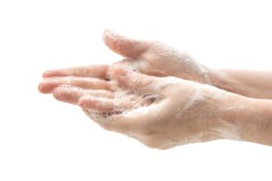 lathering soap to wash hands against white background