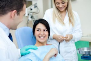 Smiling patient speaking to dentist, learning about root canal retreatment in Plymouth