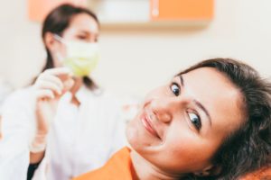 Patient smiling while dentist holds extracted tooth