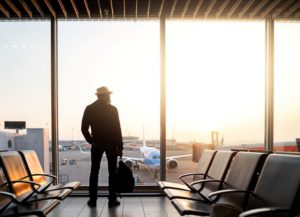 Man in airport, watching planes through the window