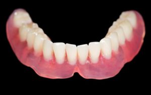 Lower denture isolated against dark background